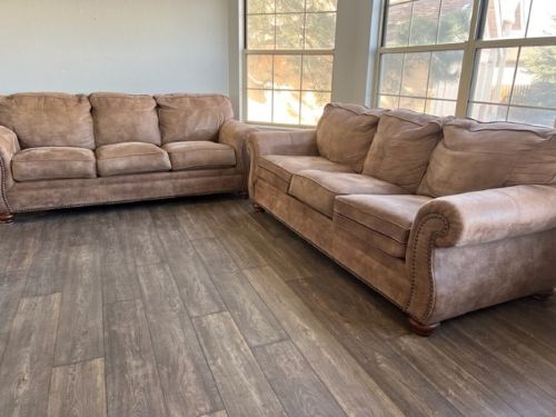 Hardwood flooring in living room with brown sofas.